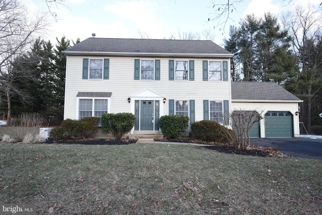 colonial-style house with a front lawn and a garage