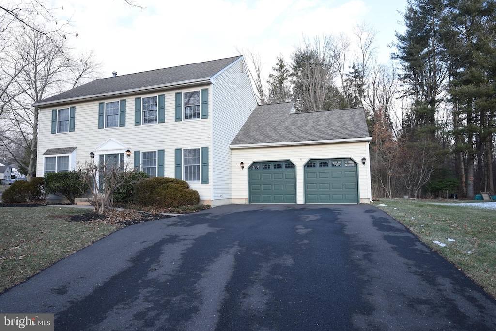 colonial home with a front yard and a garage