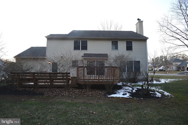 rear view of property featuring a deck and a yard