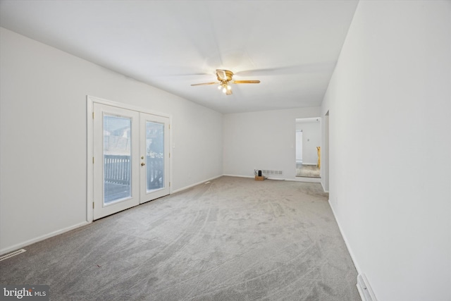 empty room with french doors, ceiling fan, and carpet