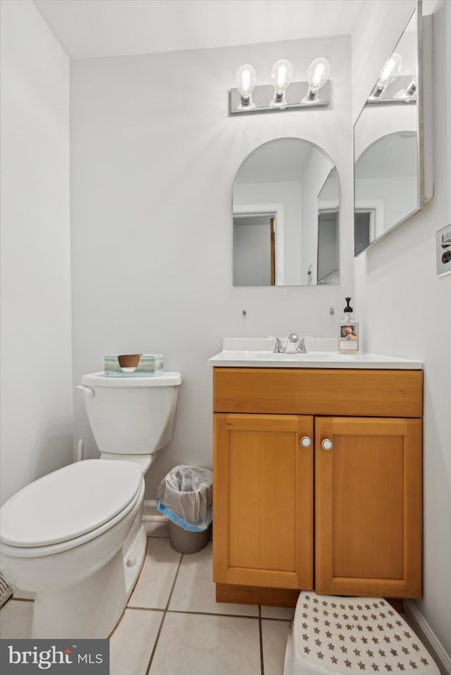 bathroom with toilet, tile patterned flooring, and vanity