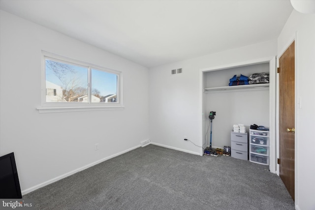 unfurnished bedroom featuring a closet and dark colored carpet