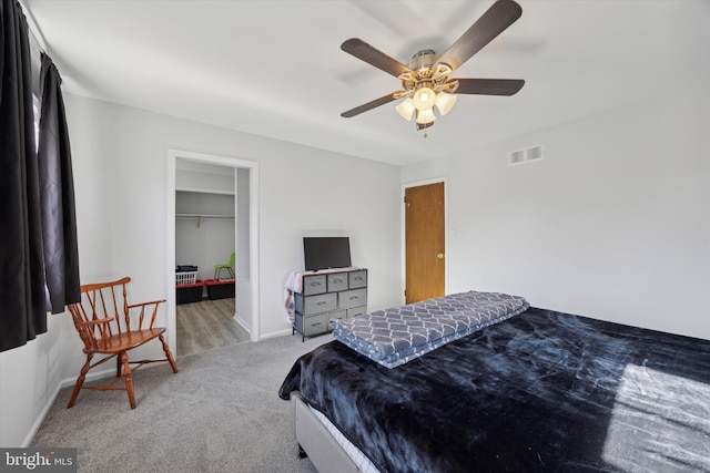 bedroom featuring carpet flooring, a closet, ceiling fan, and a spacious closet