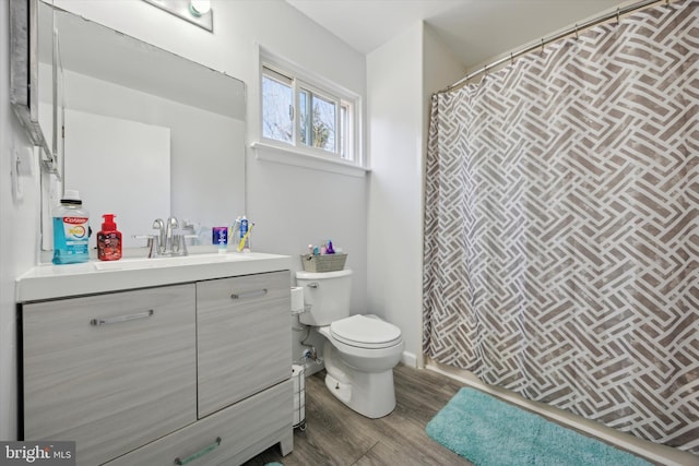 bathroom with toilet, wood-type flooring, and vanity