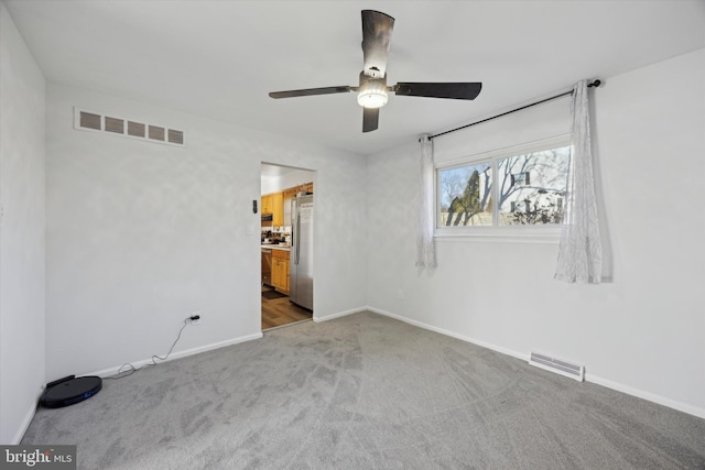 empty room featuring ceiling fan and carpet