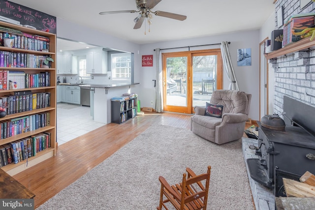 living room with sink, ceiling fan, and light hardwood / wood-style flooring