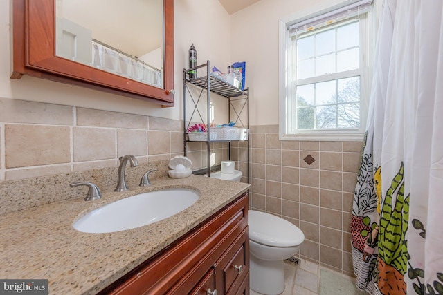 bathroom featuring toilet, vanity, tile walls, and tasteful backsplash