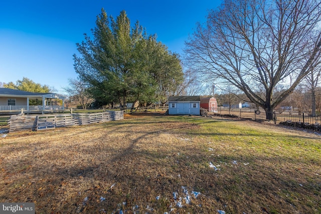 view of yard featuring a rural view and a storage shed