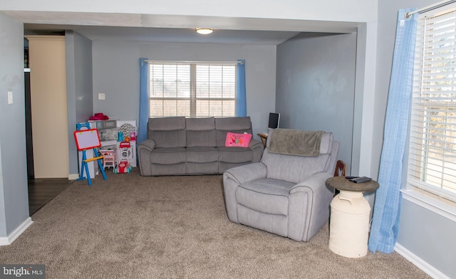 carpeted living area featuring baseboards