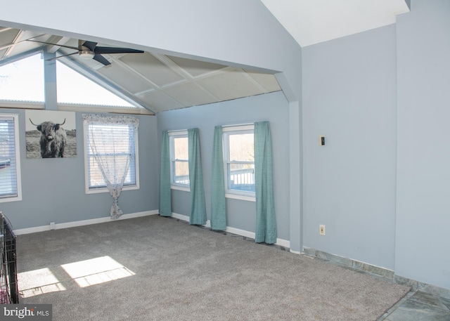 carpeted empty room featuring vaulted ceiling, baseboards, and ceiling fan