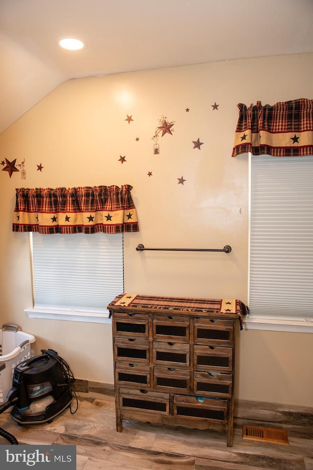 bathroom with lofted ceiling, visible vents, recessed lighting, and wood finished floors