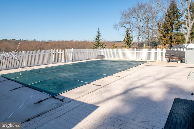 view of pool with a fenced in pool and fence