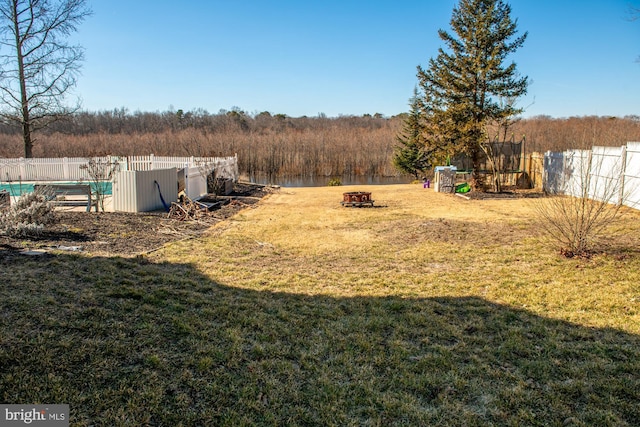 view of yard with a fire pit, a trampoline, and fence