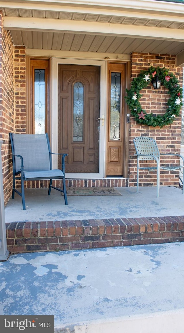 entrance to property featuring brick siding