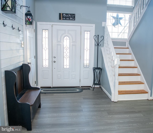 foyer entrance featuring stairs, baseboards, and wood finished floors