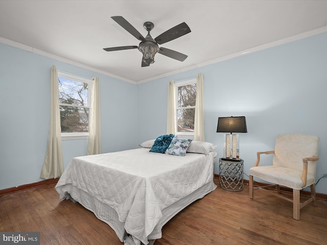 bedroom with crown molding, hardwood / wood-style flooring, and ceiling fan