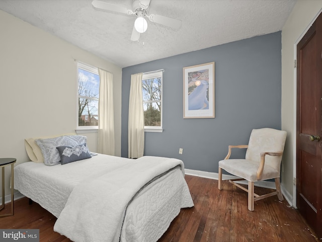 bedroom with dark wood-type flooring, a textured ceiling, and ceiling fan