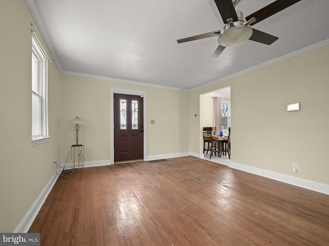 foyer with hardwood / wood-style flooring, ornamental molding, and ceiling fan