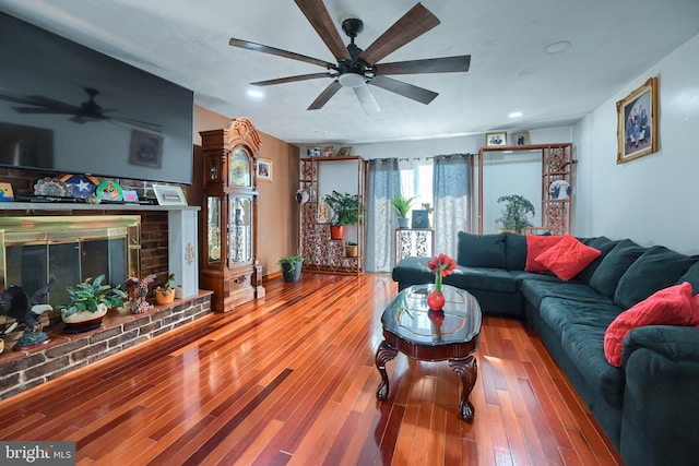 living room featuring a brick fireplace and hardwood / wood-style flooring