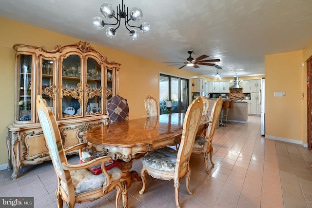 dining room featuring ceiling fan with notable chandelier and light tile patterned floors