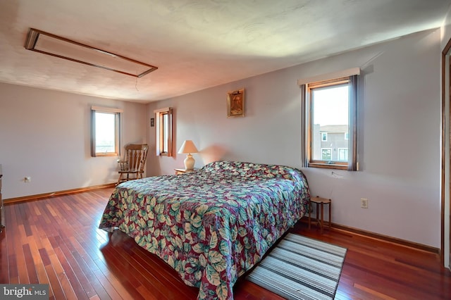 bedroom with multiple windows and hardwood / wood-style floors