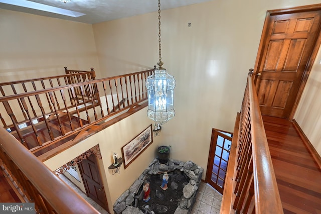 stairway featuring tile patterned flooring and a skylight