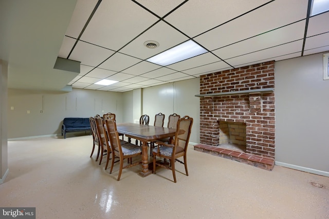 dining room featuring a paneled ceiling and a fireplace