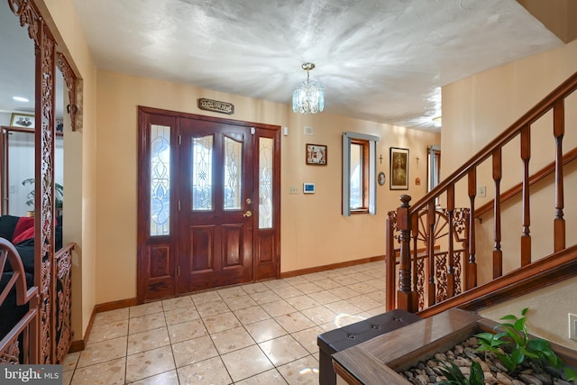 tiled foyer with a chandelier