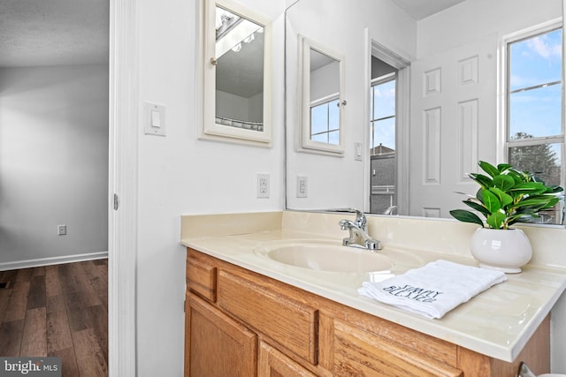 bathroom with wood-type flooring, a textured ceiling, and vanity