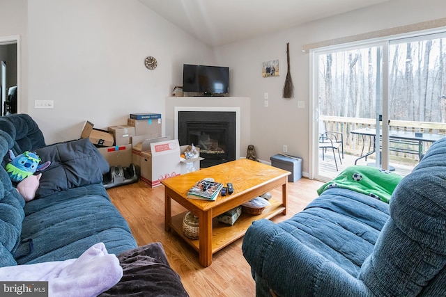 living room featuring lofted ceiling and light hardwood / wood-style flooring