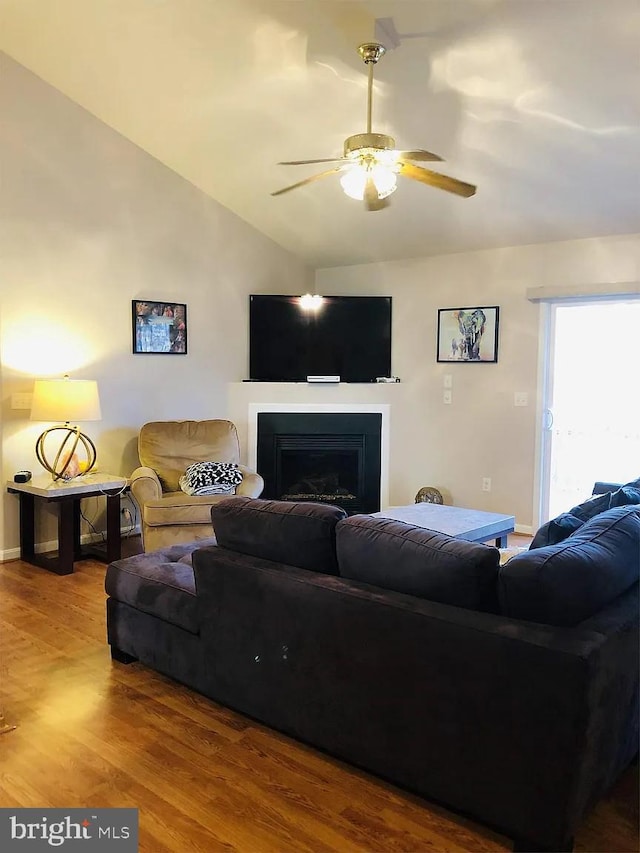 living room featuring wood-type flooring, vaulted ceiling, and ceiling fan