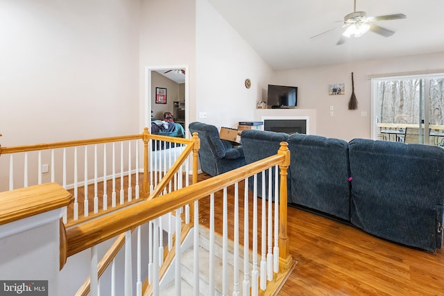 living room featuring ceiling fan, wood-type flooring, and vaulted ceiling