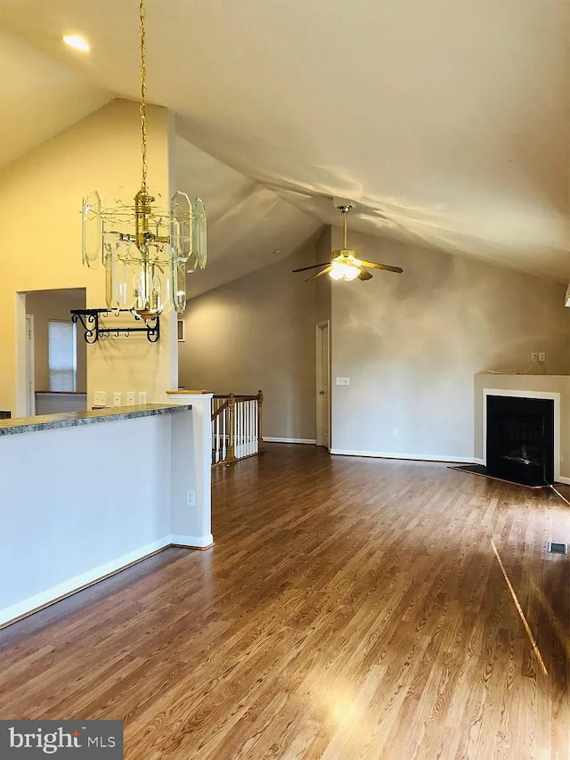 unfurnished living room with vaulted ceiling, dark hardwood / wood-style floors, and ceiling fan