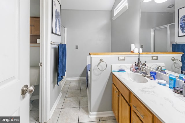 bathroom with vanity, tile patterned flooring, toilet, and walk in shower