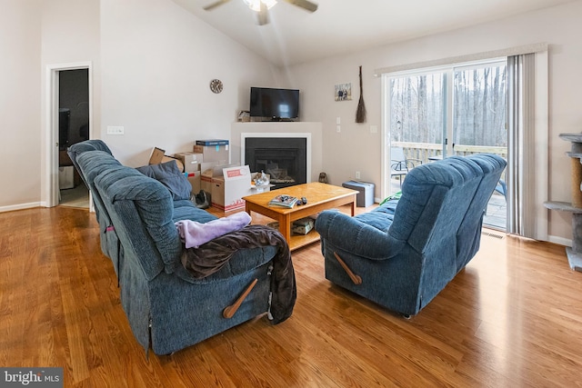 living room with ceiling fan, vaulted ceiling, and hardwood / wood-style floors