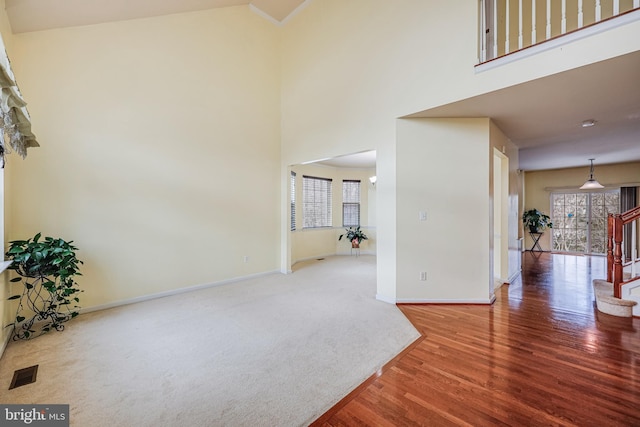 interior space with wood-type flooring and a towering ceiling