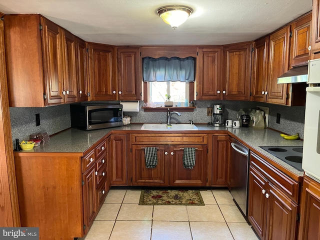 kitchen with stainless steel appliances, light tile patterned floors, decorative backsplash, and sink