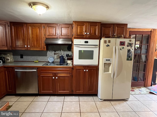 kitchen with white appliances, tasteful backsplash, and light tile patterned floors