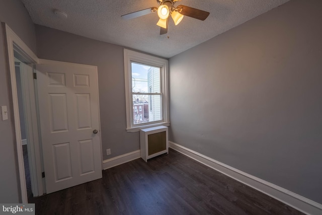 unfurnished bedroom featuring ceiling fan, dark hardwood / wood-style floors, and a textured ceiling