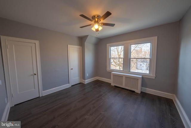 unfurnished bedroom with radiator heating unit, ceiling fan, and dark wood-type flooring