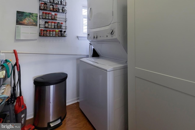 clothes washing area with stacked washer and dryer and hardwood / wood-style flooring