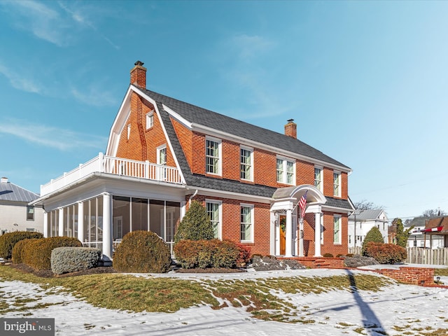 view of front of house featuring a balcony and a sunroom