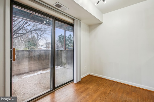 empty room with plenty of natural light and wood-type flooring