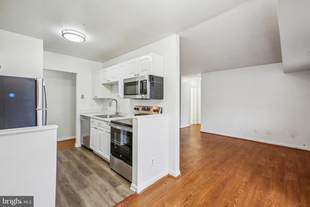 kitchen with stainless steel appliances, dark hardwood / wood-style flooring, white cabinets, and sink