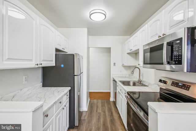 kitchen with dark hardwood / wood-style floors, appliances with stainless steel finishes, white cabinets, and sink