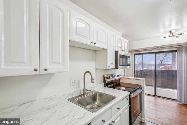 kitchen featuring white cabinets, light stone countertops, sink, and stainless steel appliances