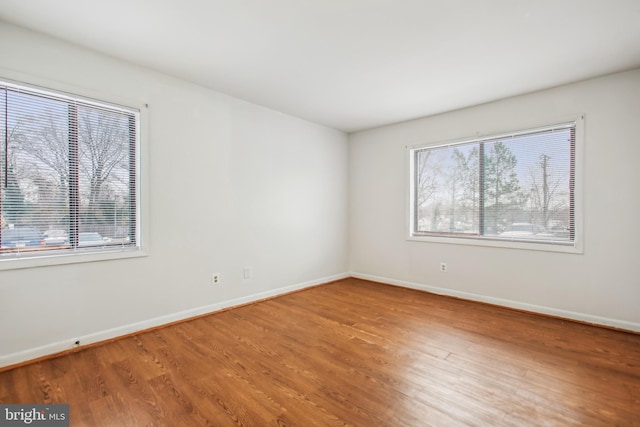 unfurnished room featuring a wealth of natural light and hardwood / wood-style flooring