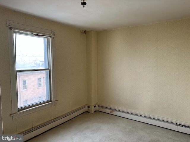 empty room with light colored carpet and a baseboard heating unit