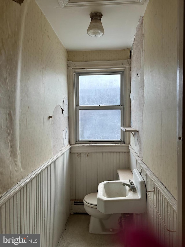 bathroom with baseboard heating, sink, and toilet