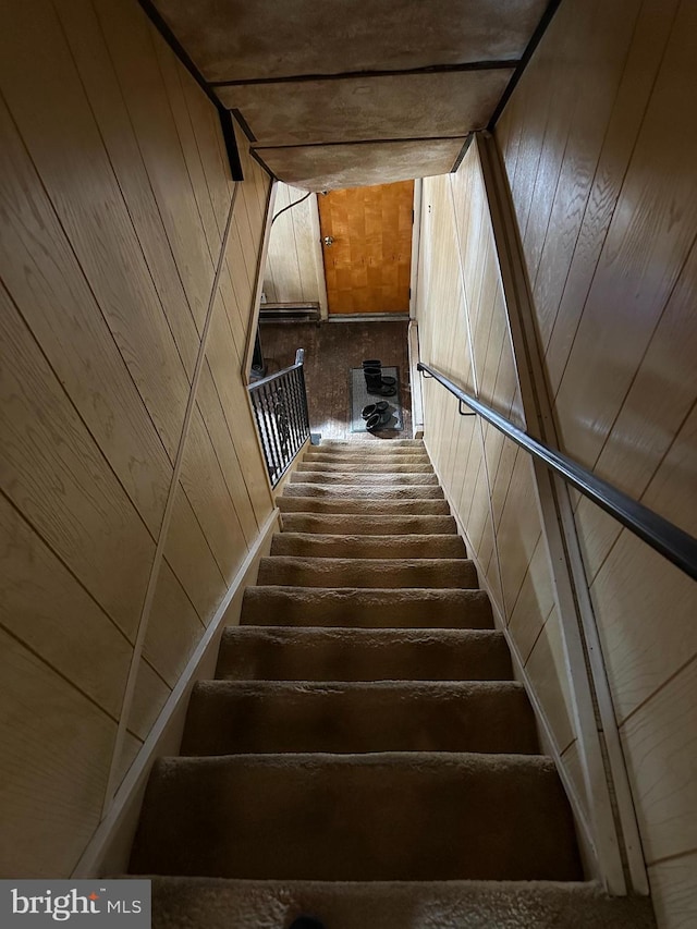 stairs featuring wooden walls